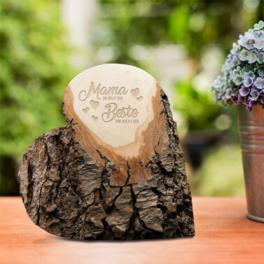Green plant in a flower pot on a wooden desk at the in front of house with blurred garden view textured background.